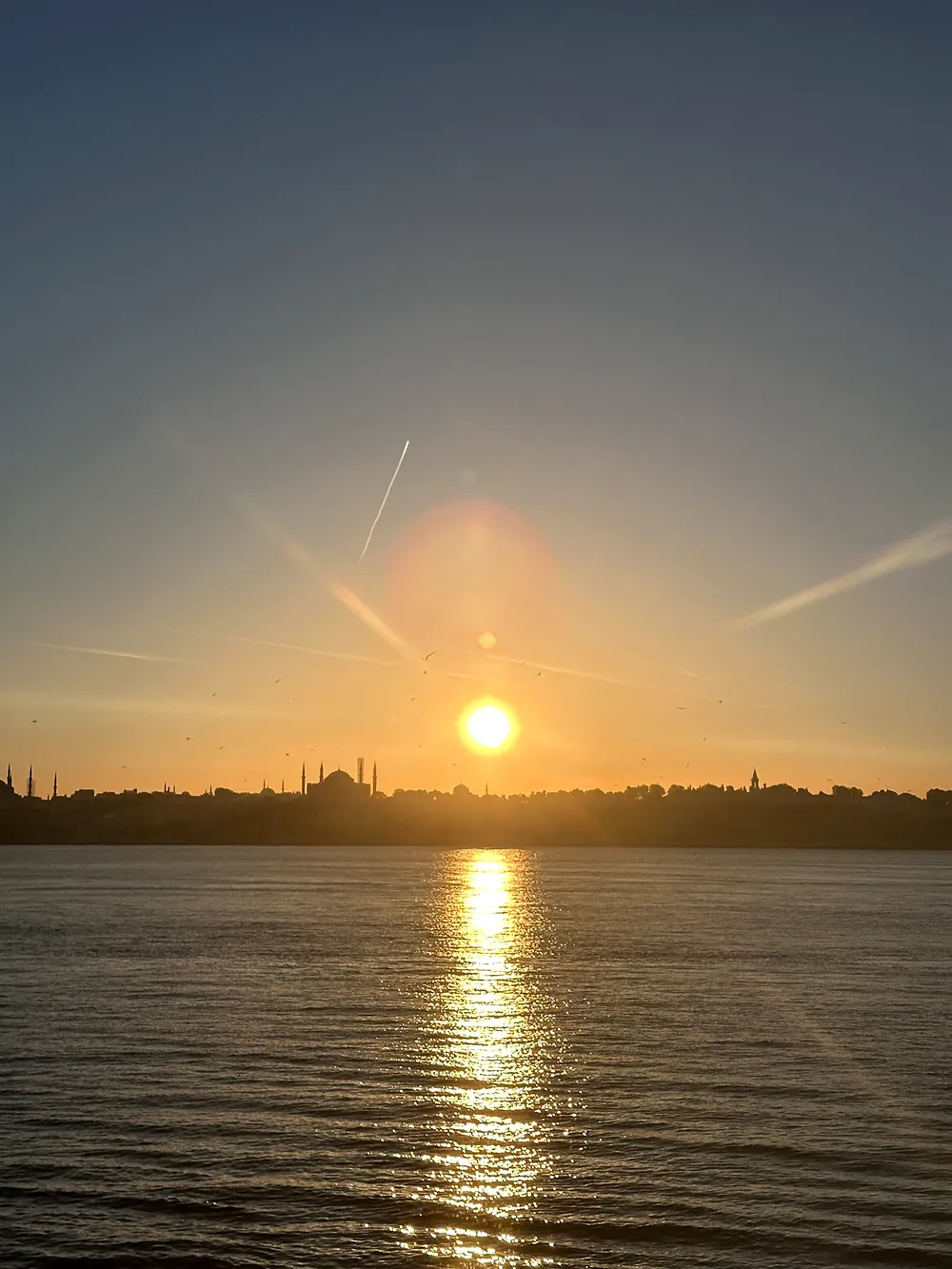 Sonnenuntergang über der Silhouette von Sultanahmet, die Sonne spiegelt sich im Meer